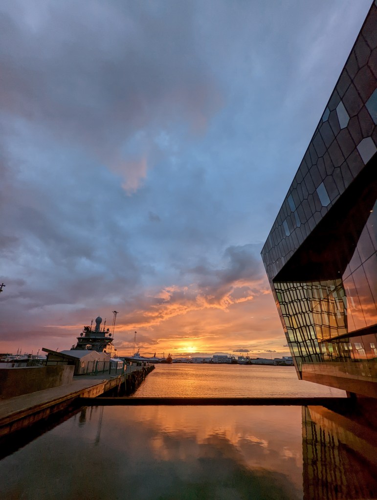 The midnight sunset in Reykjavik, Iceland over the harbor beside the Harpa Concert Hall